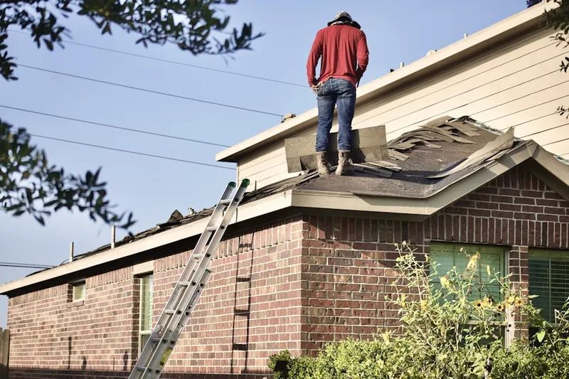 Professional roofer working on a residential roof in North Plains
